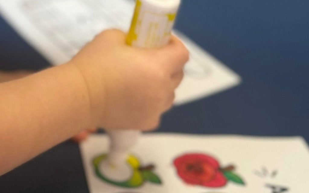Toddler using a dot marker on an apple worksheet at Sunny Pointe