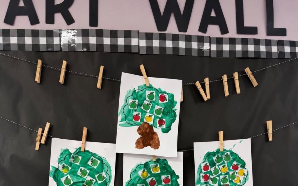 Apple tree paintings on the classroom art wall at Sunny Pointe