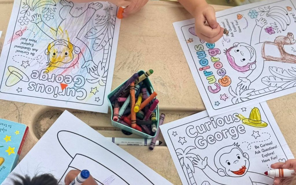 Preschoolers coloring Curious George pages at Sunny Pointe