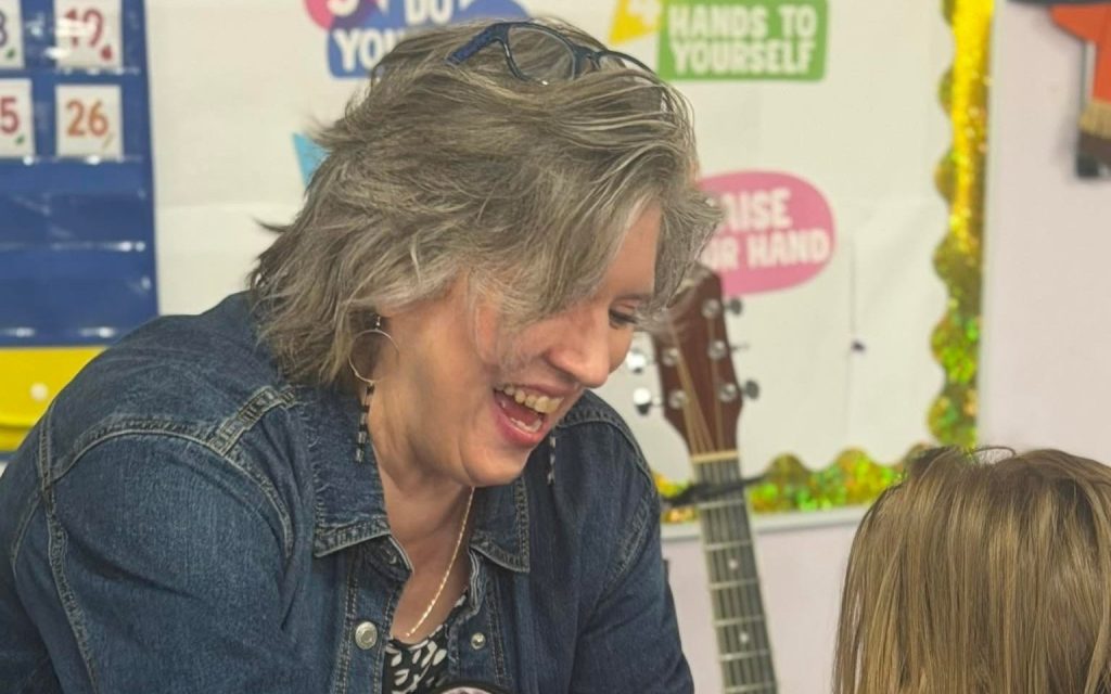 Teacher sharing a laugh with a child in a Sunny Pointe classroom