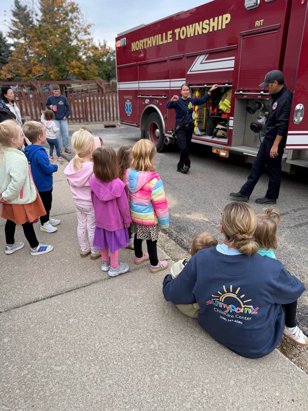 Northville Township firefighters showing Sunny Pointe children their fire truck